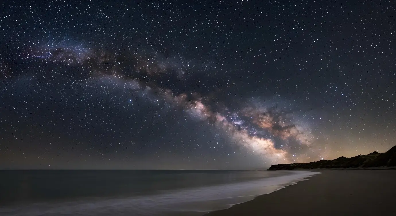 Die Milchstraße über einem ruhigen Strand bei Nacht