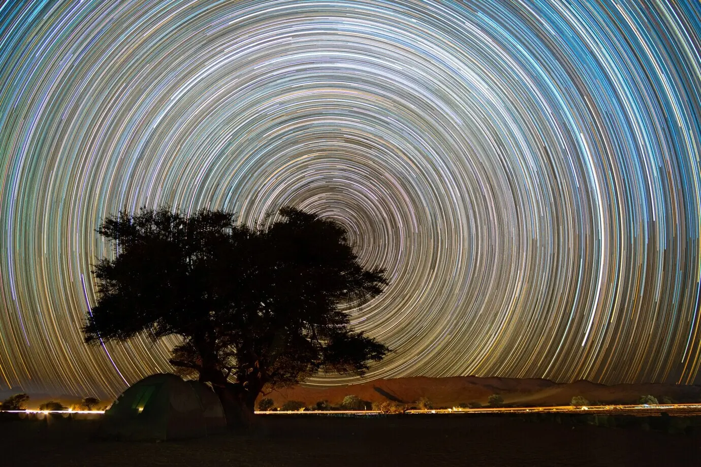 Wunderschöne Nachtlandschaft mit Sternspuren im Köcherbaumwald in Keetmanshoop, Namibia.
